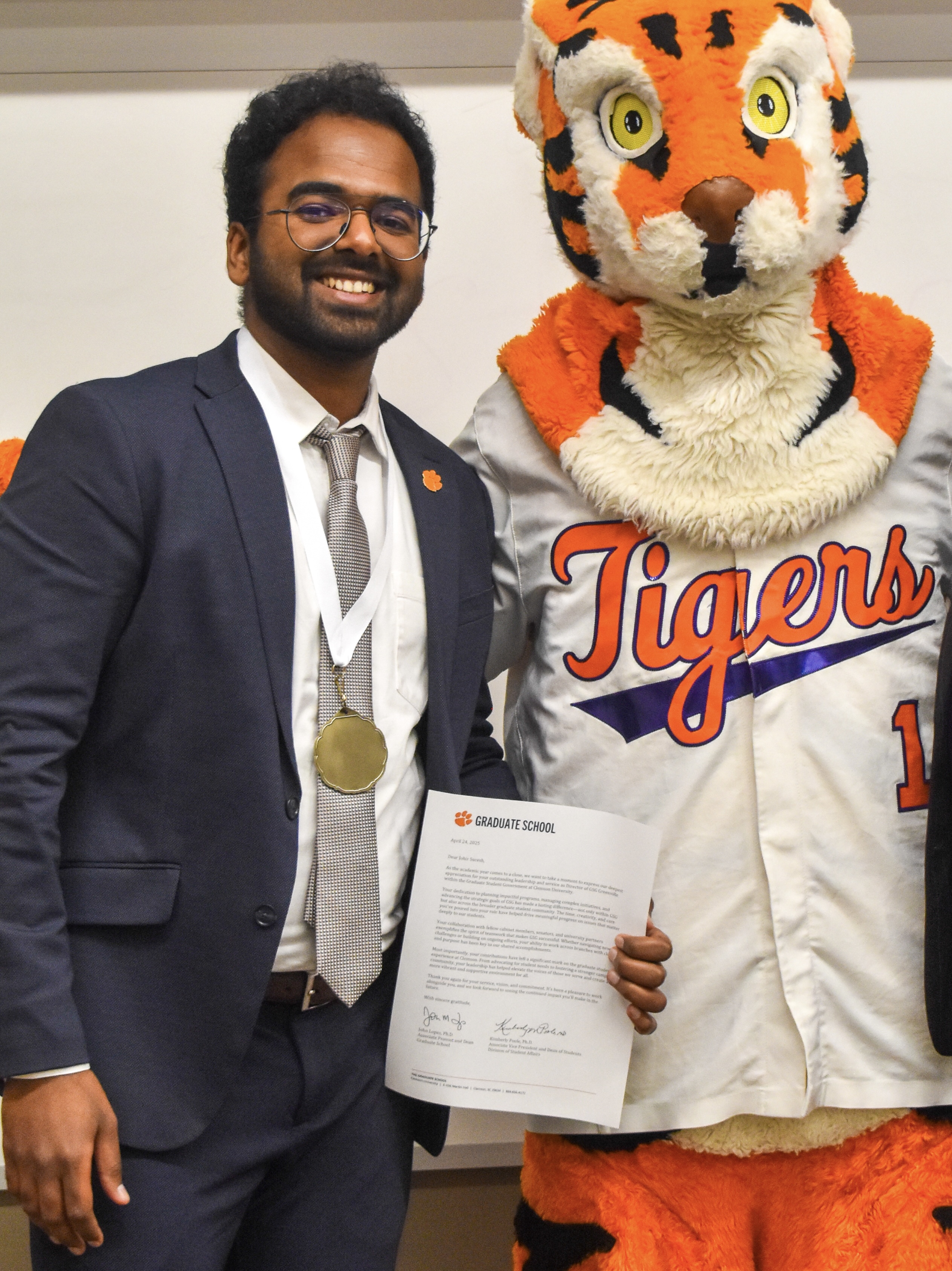 Johir Suresh standing beside a tiger mascot